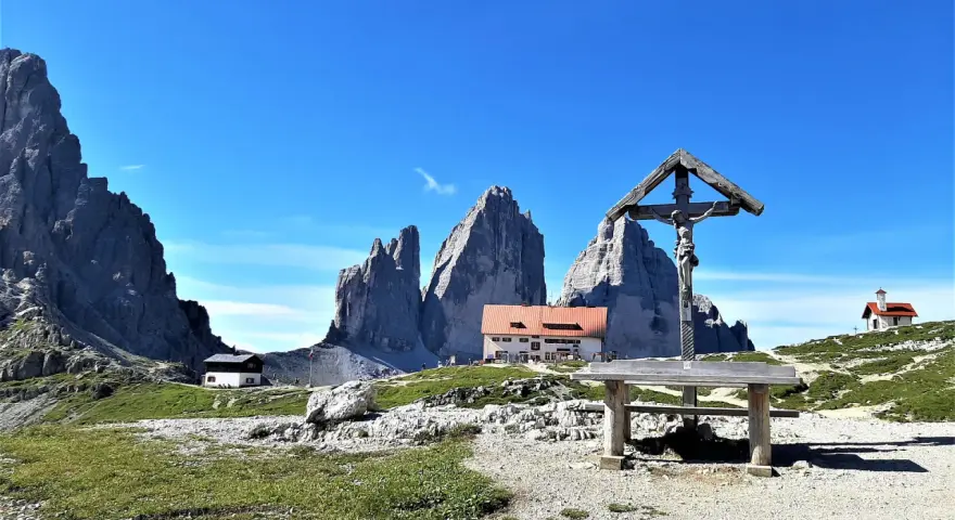 Croce e rifugio al cospetto delle Tre Cime di Lavaredo, un luogo iconico in Val Fiscalina.