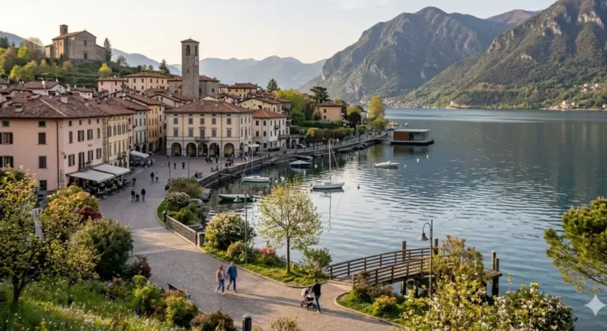 Pisogne: cosa vedere sul lago d'Iseo. Borgo con campanile, case colorate, lungolago con barche e montagne sullo sfondo.
