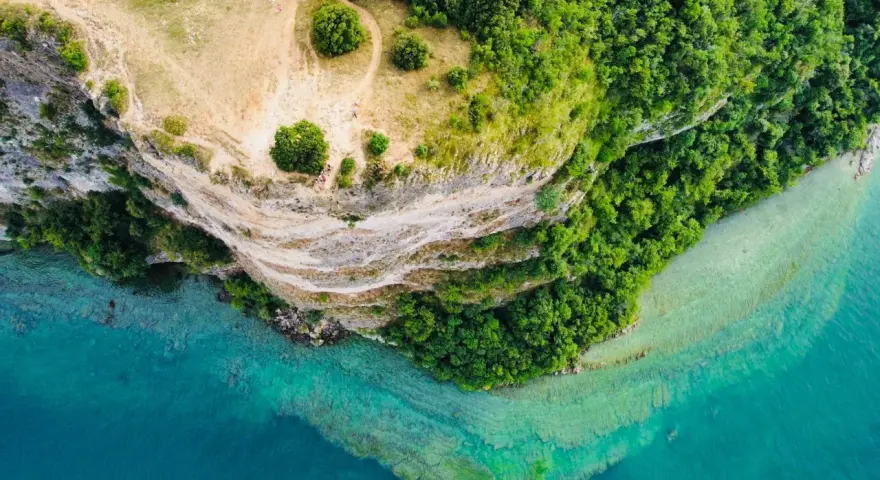 Vista aerea di Manerba del Garda: scogliere, vegetazione lussureggiante e acque cristalline del lago. Scopri cosa vedere in questo incantevole angolo del Garda.