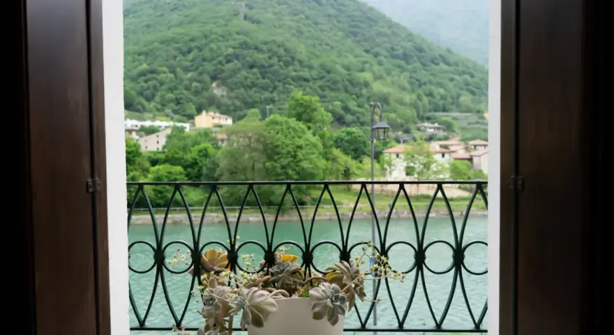 Balcone fiorito con vista sul lago e montagne verdi, un angolo di pace a Cismon del Grappa.