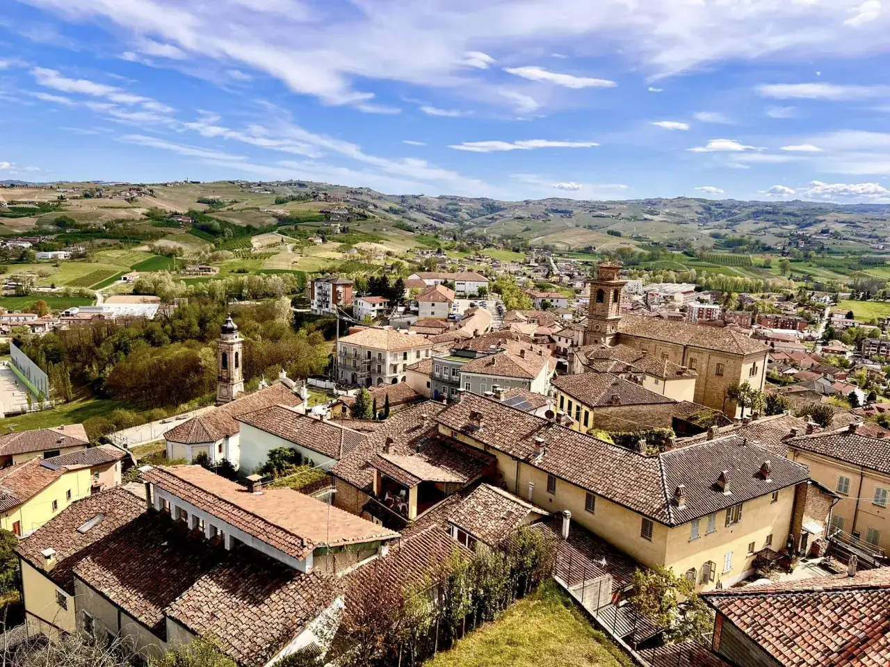 Panoramica di Castagnole delle Lanze, con tetti rossi e colline verdi. Cosa vedere in questo borgo piemontese.
