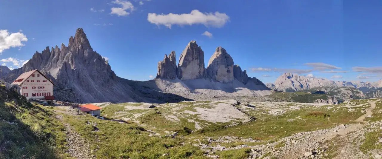 Rifugio Auronzo, con le Tre Cime di Lavaredo sullo sfondo. Un sentiero panoramico conduce al rifugio, ideale per chi cerca come arrivare in questo luogo magico.