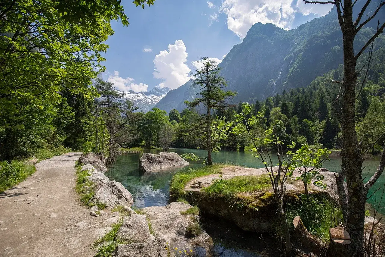 Sentiero in montagna in Lombardia, lago alpino cristallino e vette innevate. Perfetto per una gita in giornata.