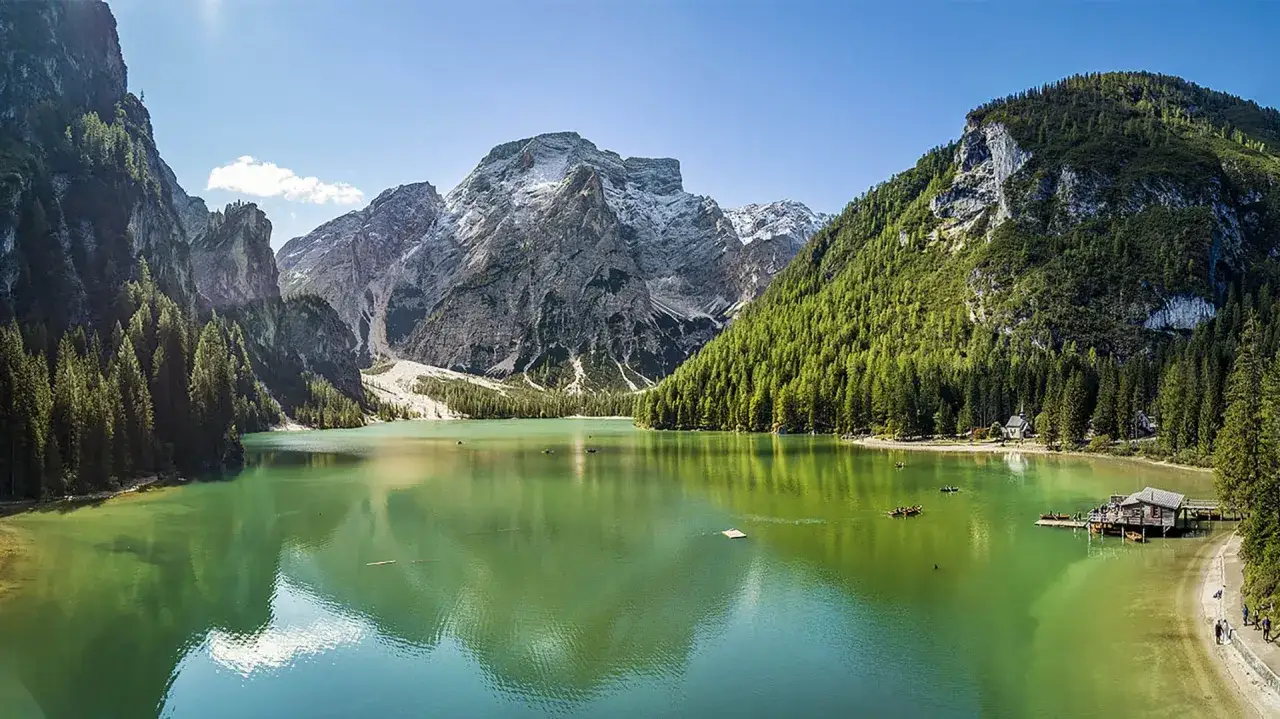 Laghi alpini smeraldini vicino Vipiteno, circondati da foreste di conifere e maestose montagne innevate. Barche a remi solcano le acque tranquille.