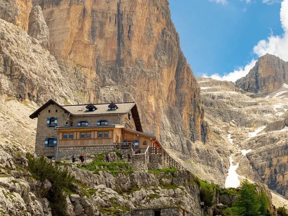 Rifugio alpino in Trentino, meta ideale per un trekking di 2 giorni tra imponenti pareti rocciose e cime innevate.