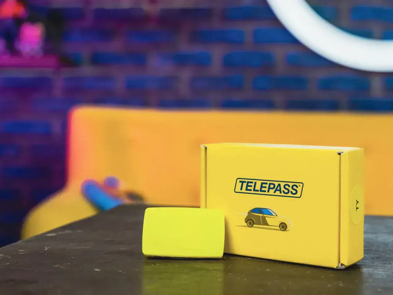 Scatola gialla Telepass con dispositivo, pronta per il tuo prossimo viaggio. Un comodo recesso telepass per viaggiare senza pensieri.