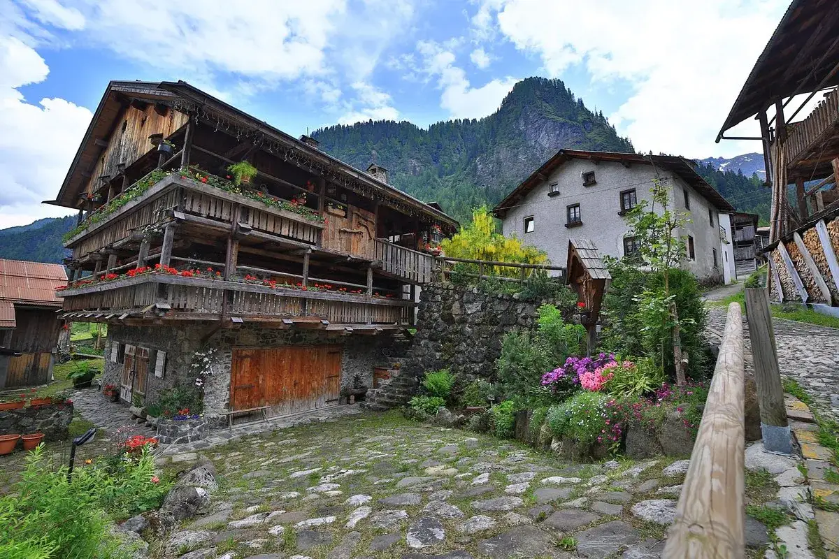 Antica rocca Pietore con balconi fioriti e montagne sullo sfondo.