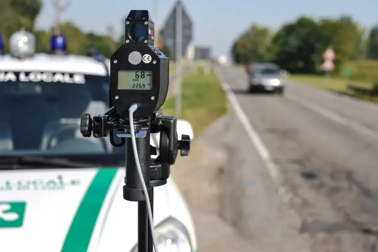 Autovelox mobile come funziona: un dispositivo su un'auto della polizia locale misura la velocit&agrave; di un veicolo in transito.