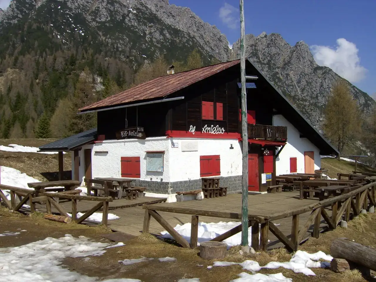 Rifugio Antelao, con tavoli esterni e montagne sullo sfondo. Ecco come arrivare a questo rifugio alpino.