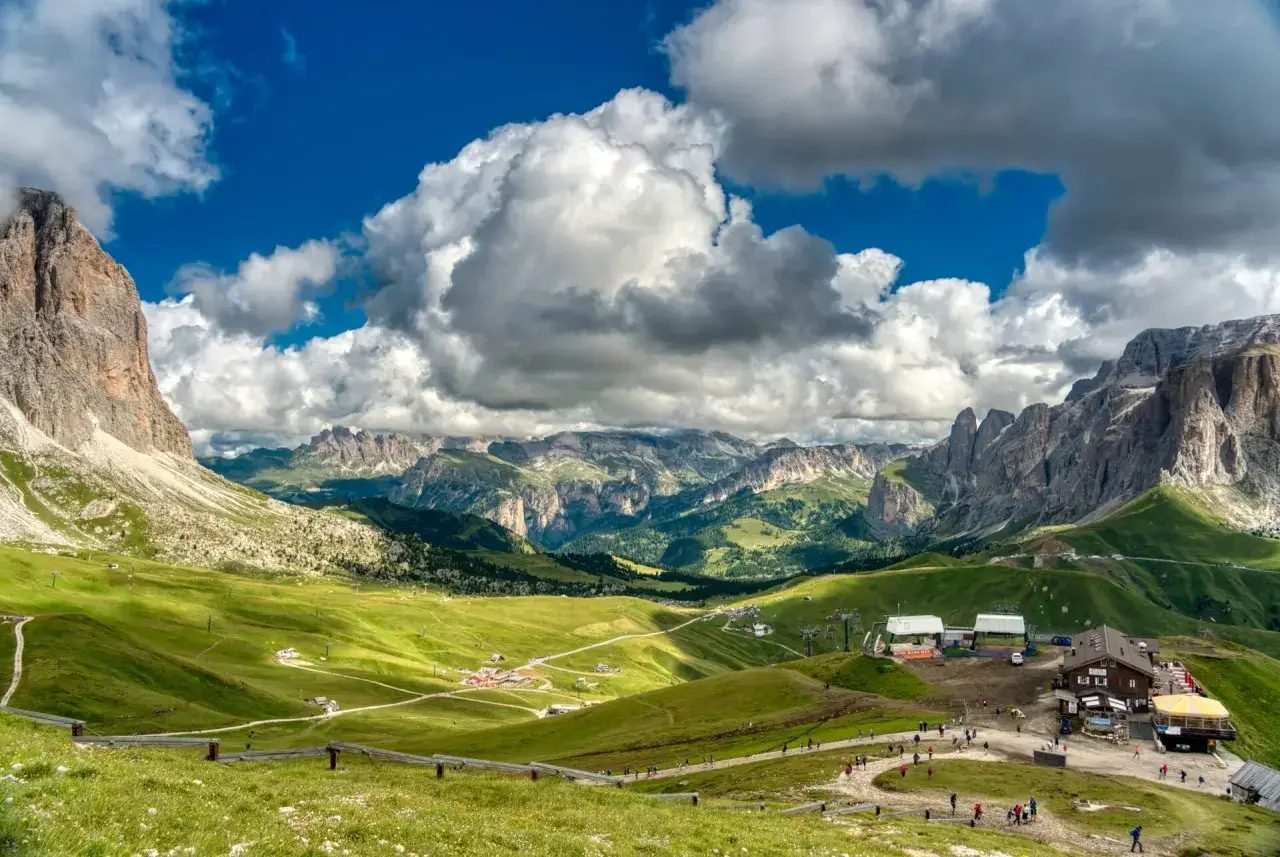Panoramica mozzafiato delle Dolomiti con il Col Rodella. Sentieri verdi, rifugi e impianti di risalita invitano a scoprire come arrivare.