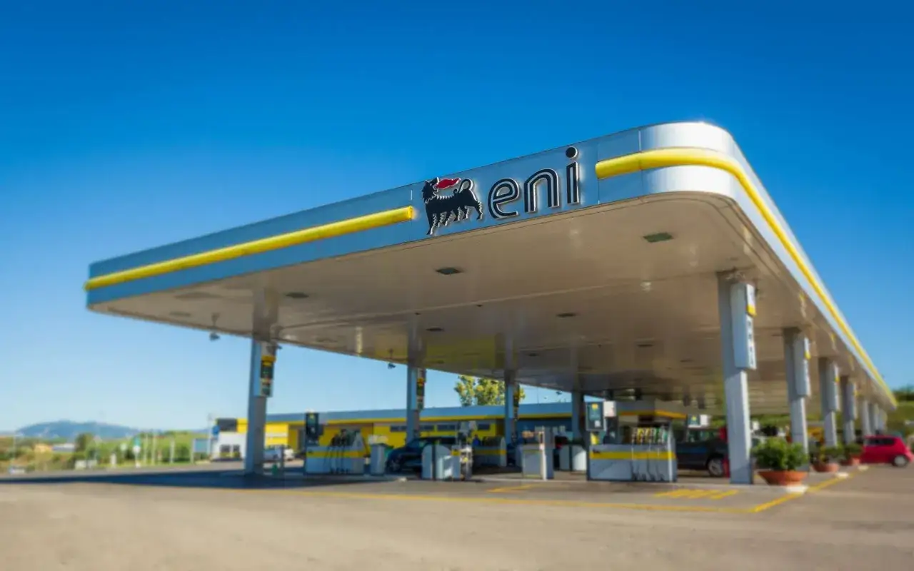 Stazione di servizio Eni con il logo del cane a sei zampe. Le pompe di benzina sono pronte per il rifornimento, con la possibilità di pagare tramite Telepass.