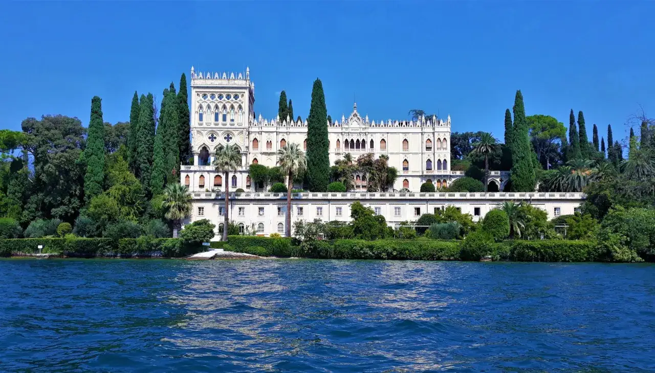 Villa neogotica sull'acqua, circondata da cipressi e palme. Un'oasi di pace, perfetta per consultare l'isola del Garda fahrplan.