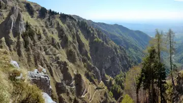 Sentiero tortuoso che si snoda sui ripidi pendii delle Prealpi Venete, ideale per escursioni panoramiche.