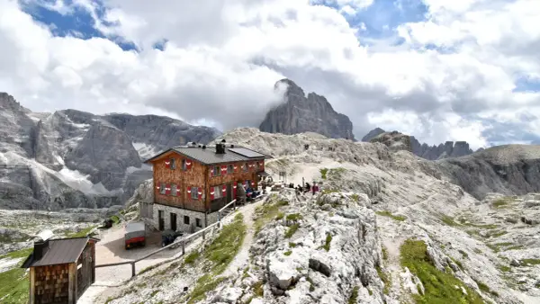 Rifugio Pian di Cengia, un accogliente rifugio alpino tra le maestose Dolomiti, con escursionisti che riposano.