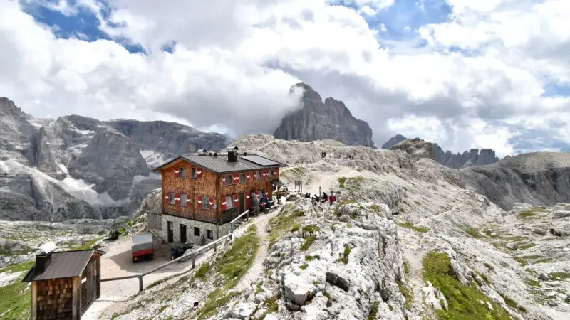 Rifugio Pian di Cengia, un accogliente rifugio alpino tra le maestose Dolomiti, con escursionisti che riposano.